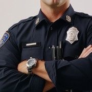 Torso of a uniformed police officer with arms folded